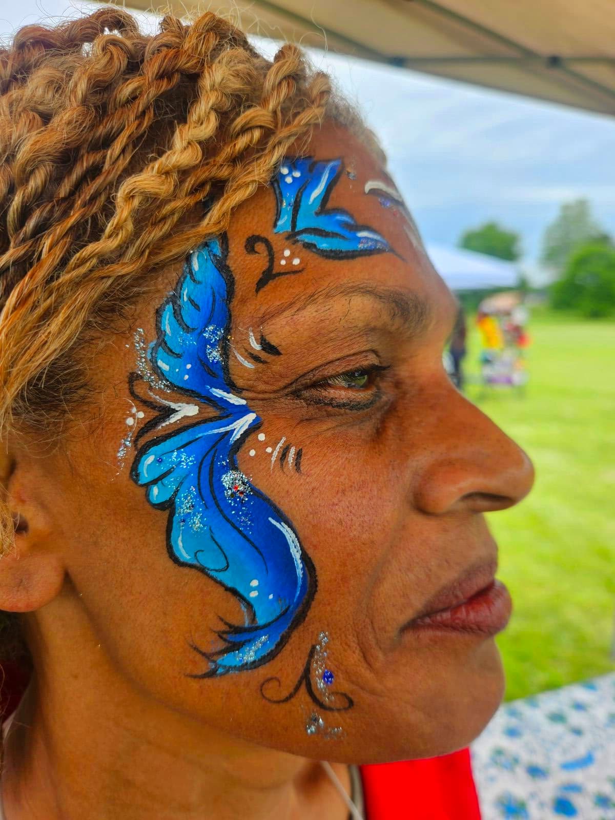 Woman with a sparkling blue wave design painted across her eyes