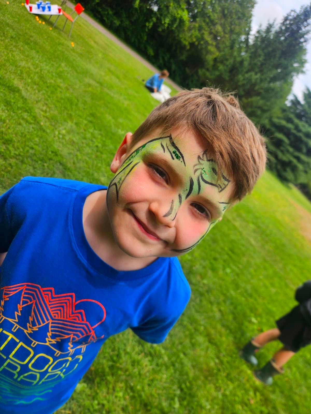 Boy with a green dragon face paint design