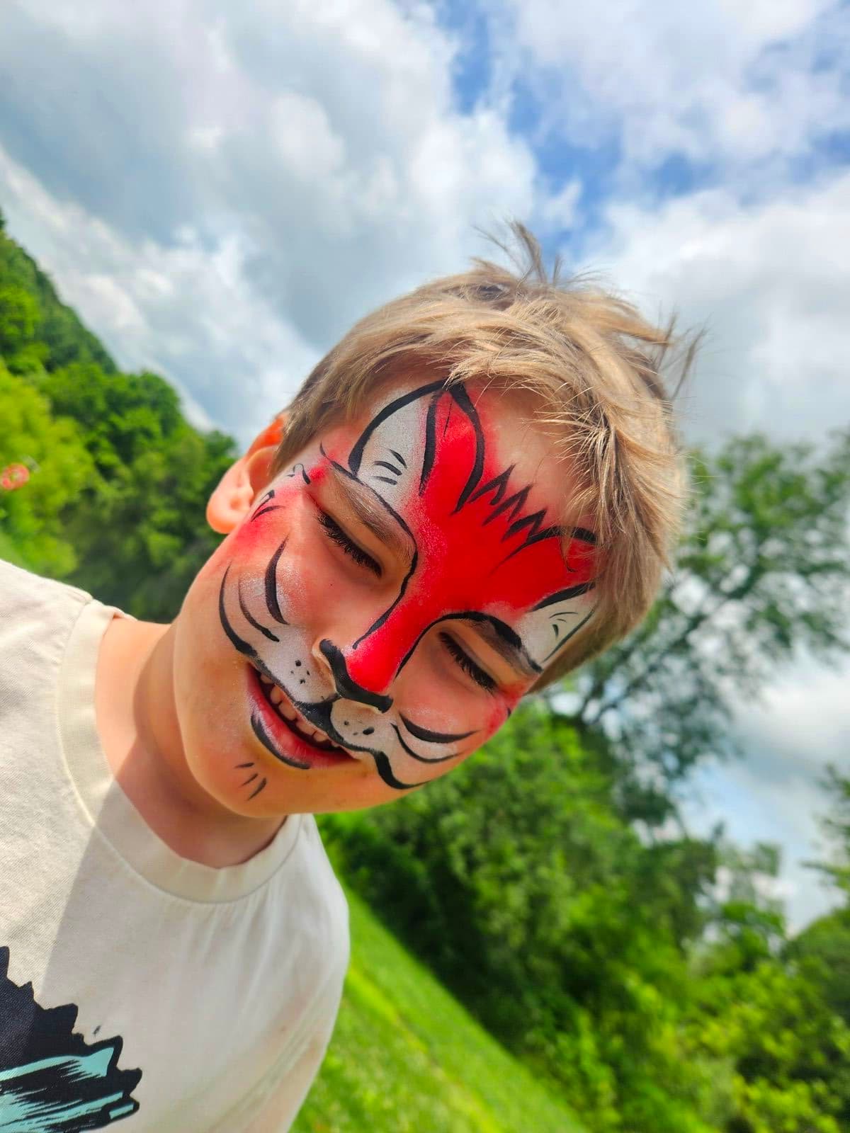 Boy with a red and white fox face paint design