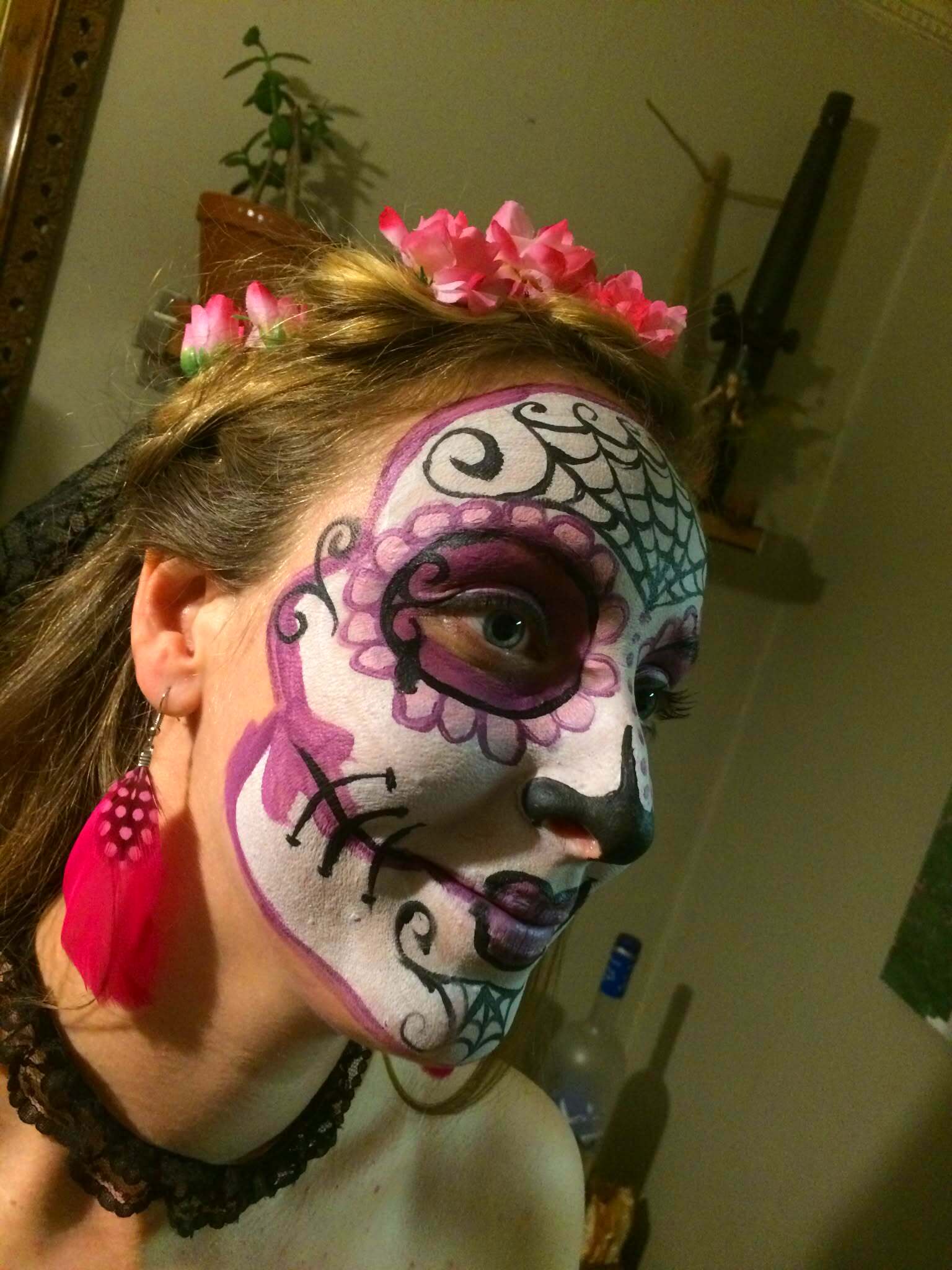 Woman in full purple and white sugar skull face paint with spider web details